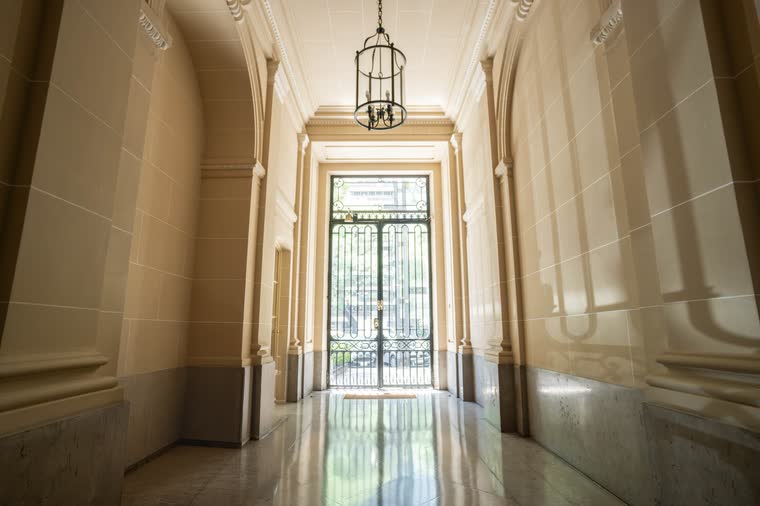 Hall de entrada de edificio con columnas y farol colgante