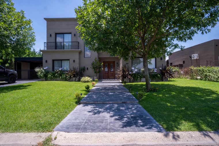 Frente de la casa con camino de entrada y jardín